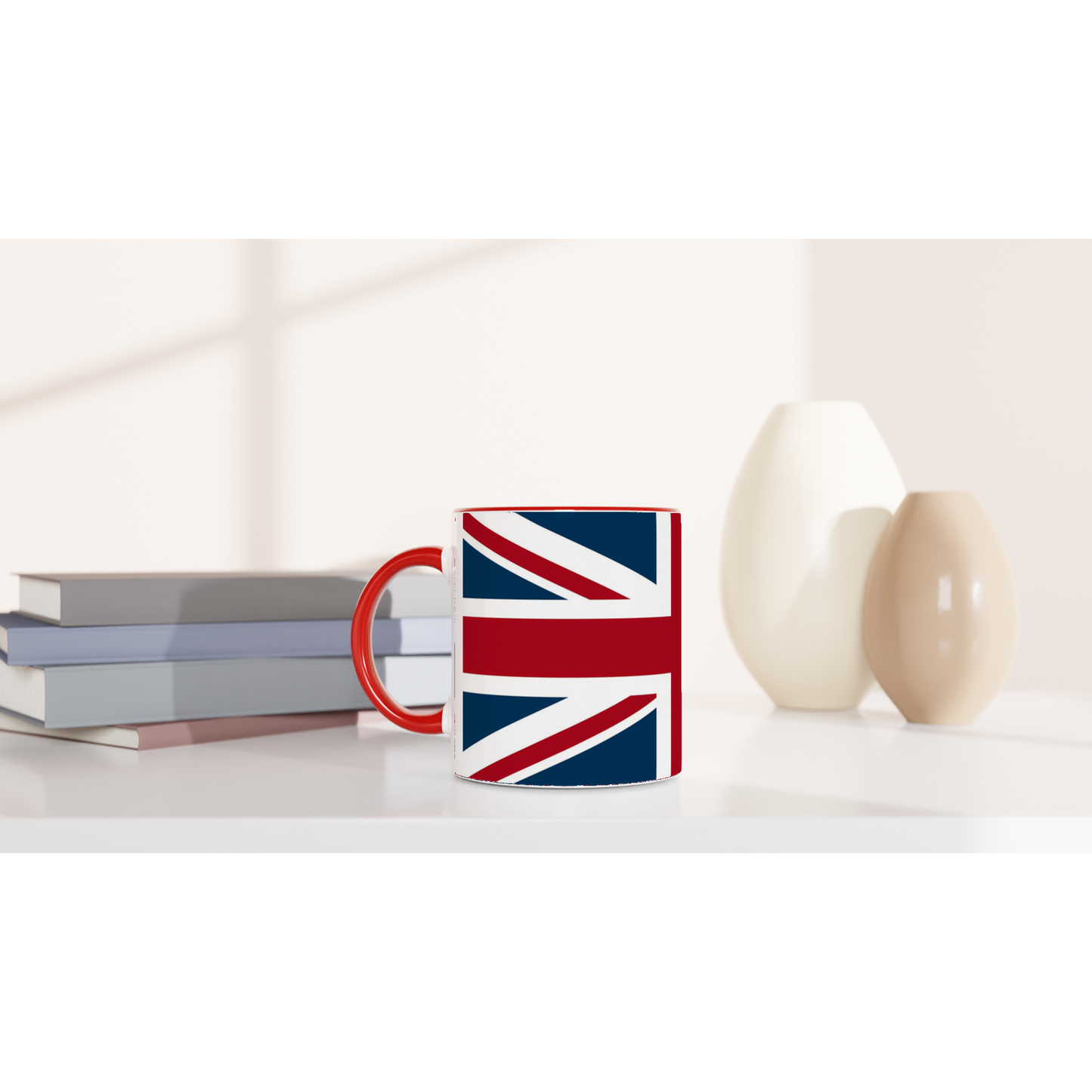 Mug with Union Jack design on a white surface with books and decorative items.